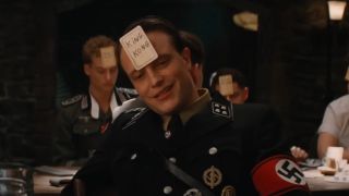 August Diehl wearing a card on his head while playing a game in Inglourious Basterds .