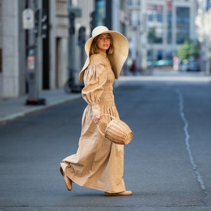 Amelie Stanescu is seen wearing beige Ganni dress, floppy hat COS, Maison Margiela tabi shoes, Mango basket bag on June 29, 2021 in Berlin, Germany.