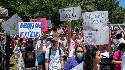 Protesters hold up signs at a protest outside the Texas state capitol