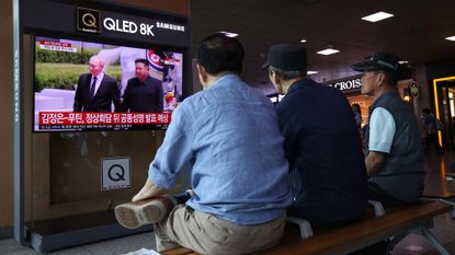 South Koreans watch a news report on the meeting between Kim Jong Un and Vladimir Putin on a TV screen at Seoul railway station