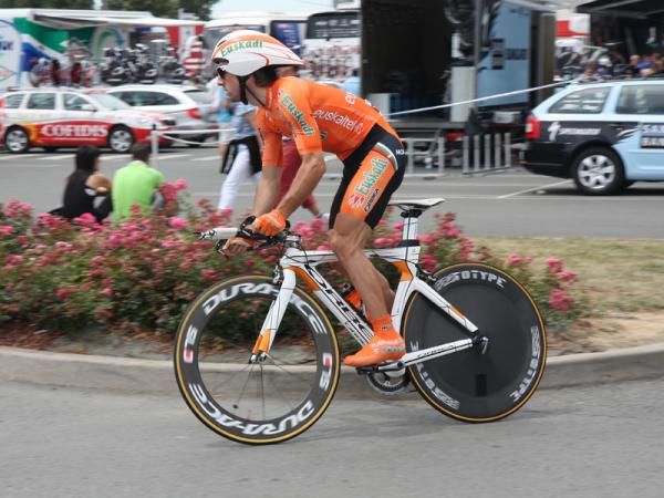 A Euskaltel-Euskadi rider stands up to put some power through his legs and warm up before the start.