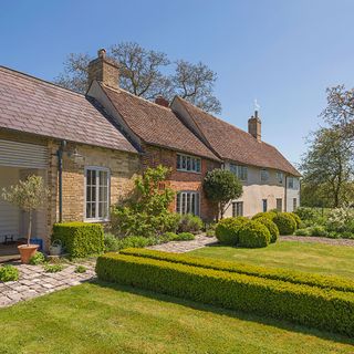 exterior farmhouse with potted plant and trees