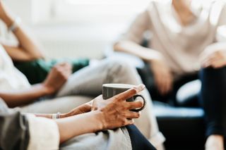 A woman drinking a coffee with a friend