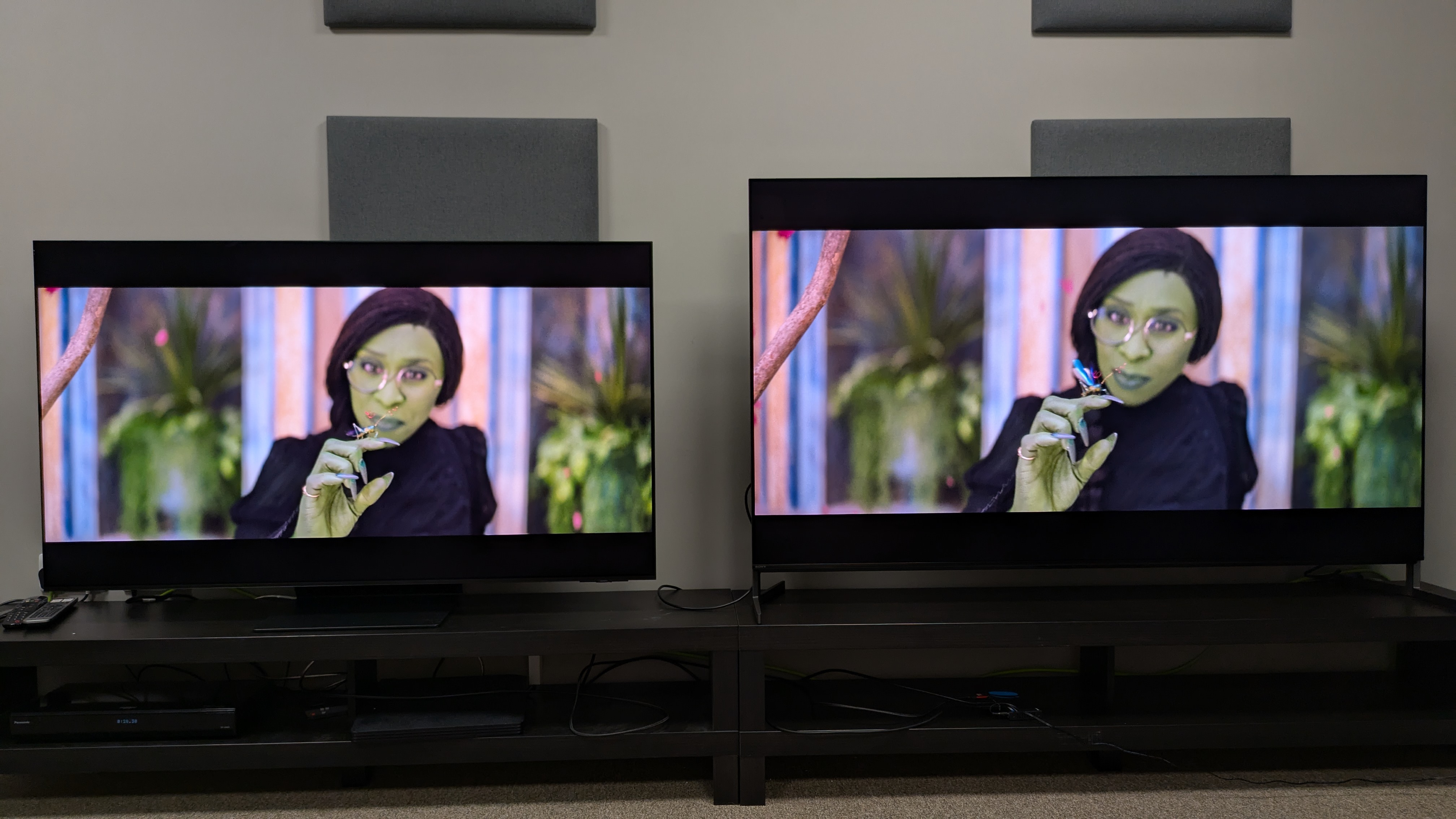 Samsung S95F (left) and Sony Bravia 8 II (right) with Elphaba from Wicked with a dragonfly on her finger on screen