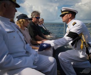 Neil Armstrong's wife Carol receives the American flag to honor her husband during his burial at sea.