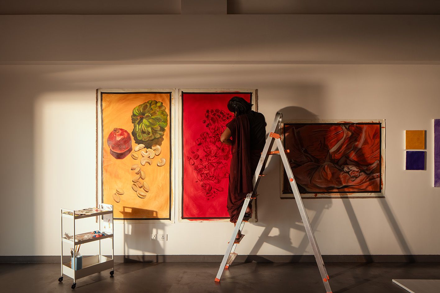 woman hanging displays at Hampi Art Labs