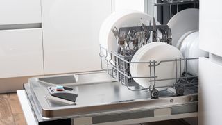 An open dishwasher full with washed dishes