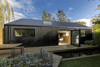 timber frame house extension clad in corrugated metal