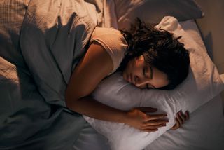A woman sleeping in bed peacefully.