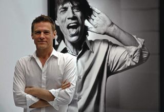 Bryan Adams and one of his portraits of Mick Jagger.