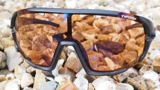 A pair of riding glasses on a pile of pebbles