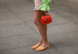 a woman wearing the Hermès Oran sandal