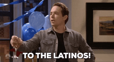 A man raises a wine glass and says "To the Latinos!"