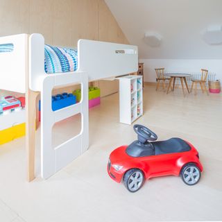 A kid's bedroom with a high bed and toys