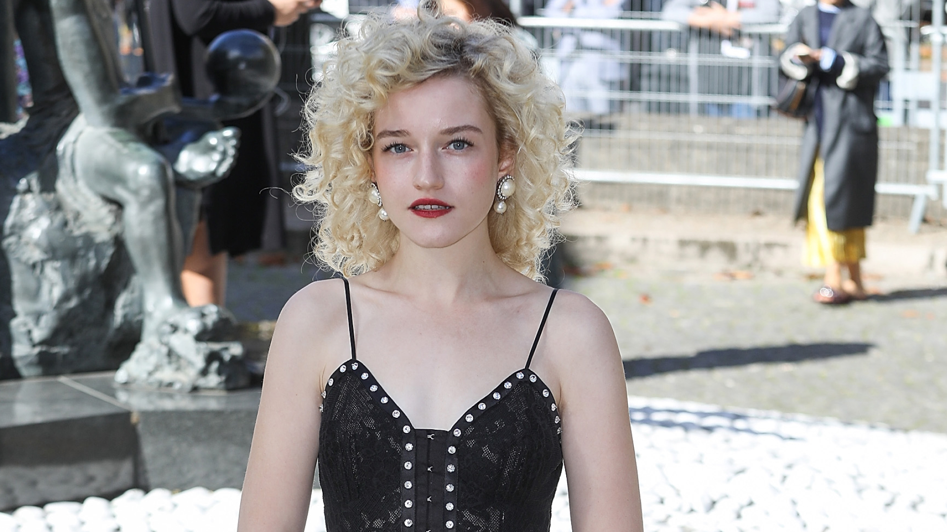 Julia garner posing in front of a camera and wearing red lipstick