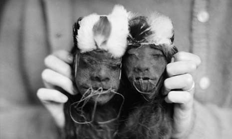 An anthropologist holds male and female shrunken heads from Ecuador. 