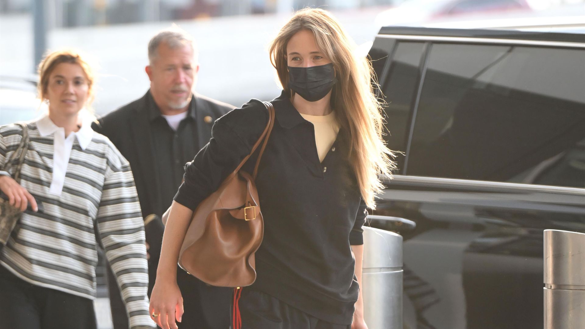An image of Jennifer Lawrence wearing a polo with Adidas tracksuit and water shoes. 