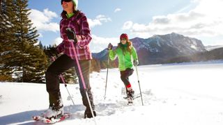 Best snowshoes – Two women snowshoeing in Hyalite Canyon on a sunny winter day.
