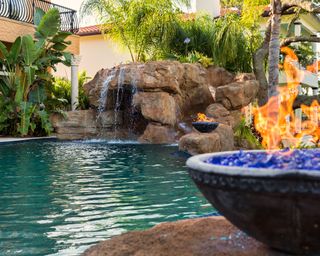 swimming pool waterfall with fire pit