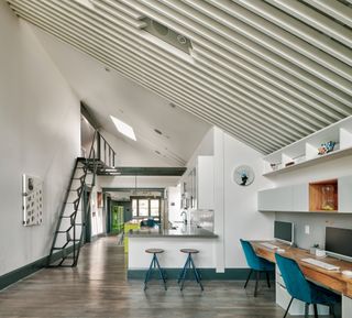 Open plan kitchen and office area with staircase leading to a loft at Alameda Renovation