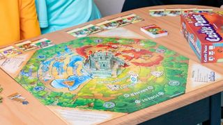 Castle Panic board, cards, and components on a wooden table