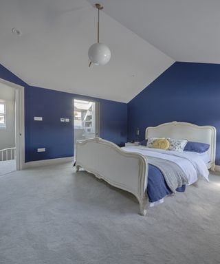 Bedroom with bed and wardrobe in mansard loft conversion
