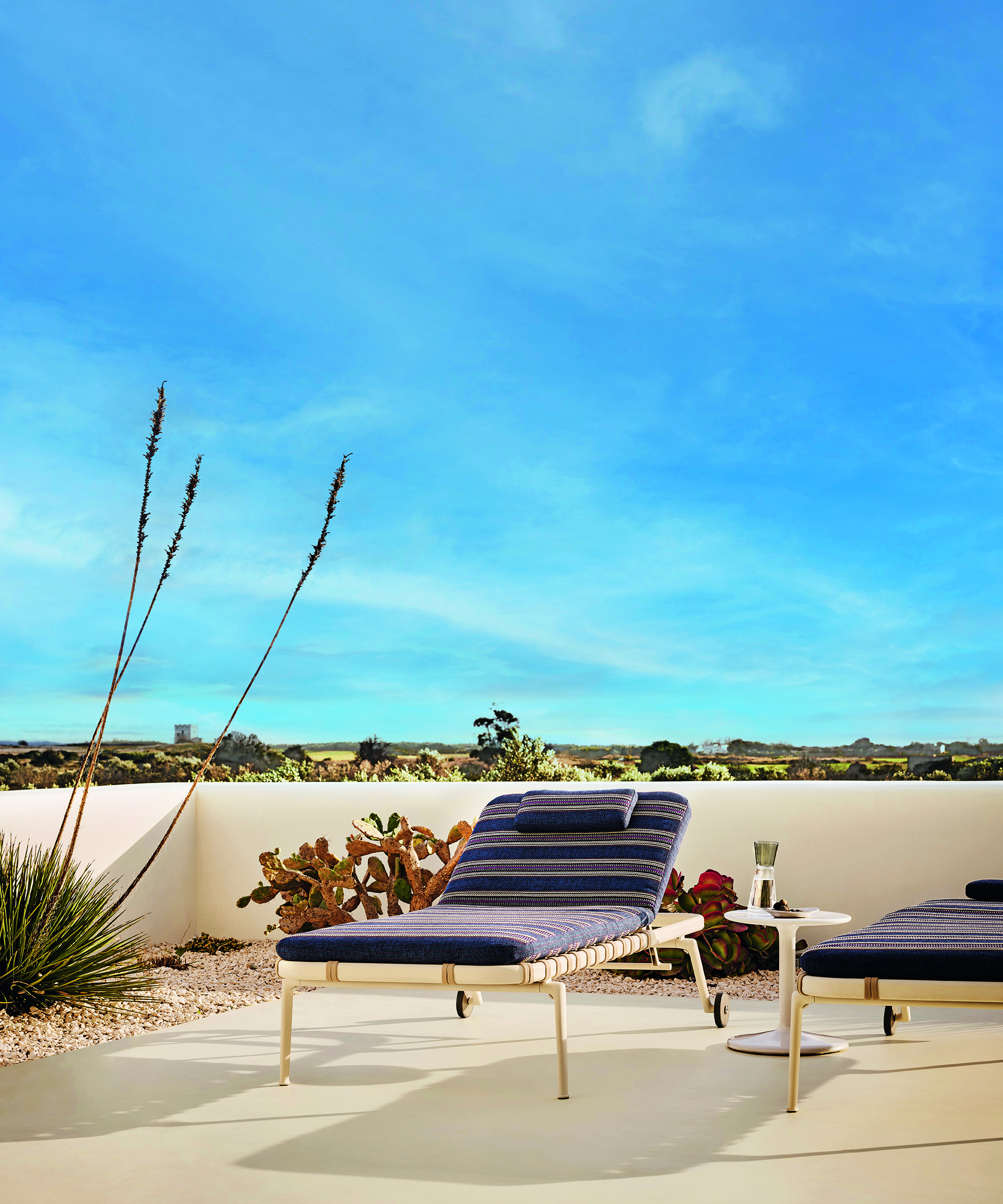 white outdoor lounger with a striped cushion