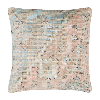 A woven floral cushion cover in muted pink and blue