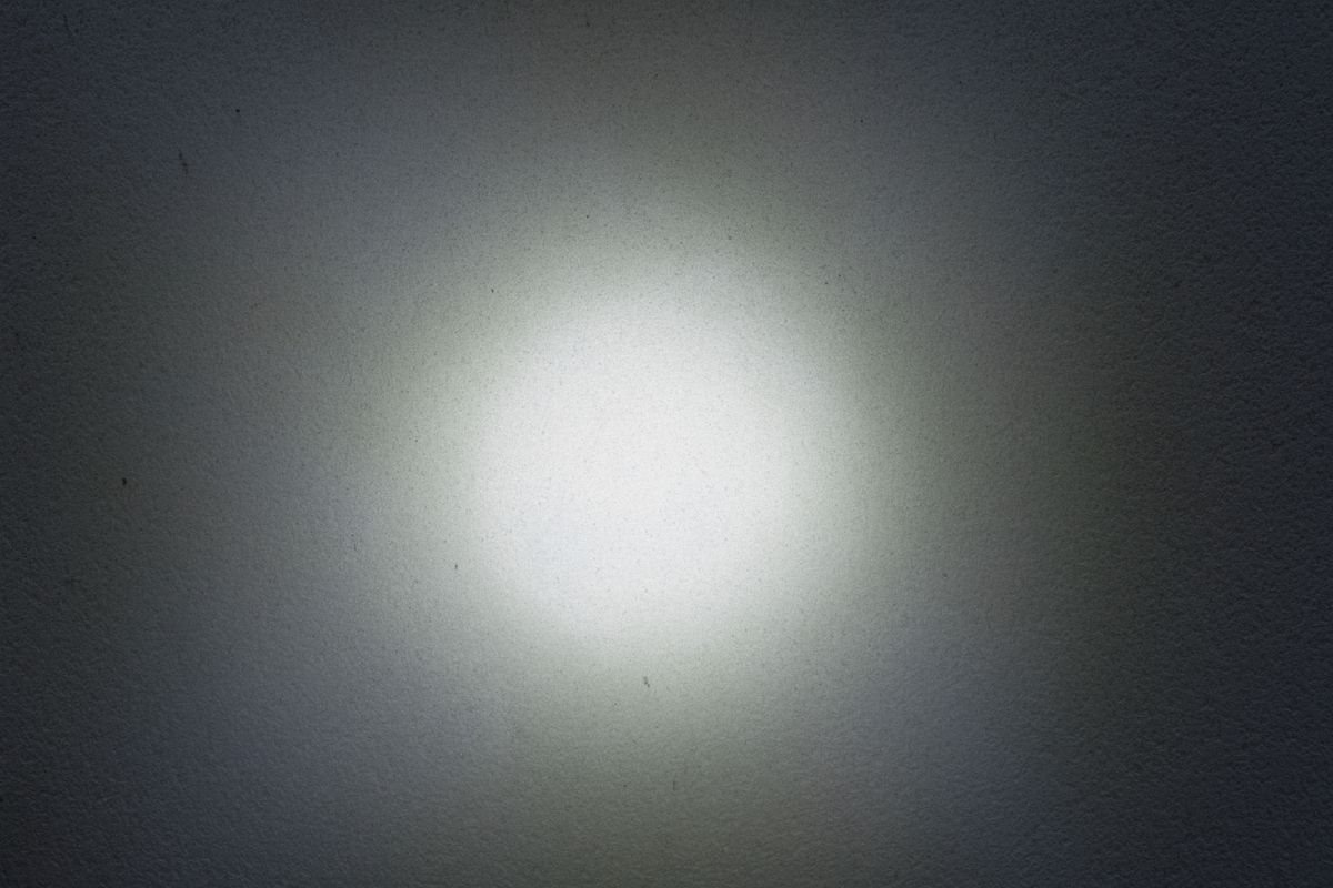 A light source shone at a black wall to show the beam shape