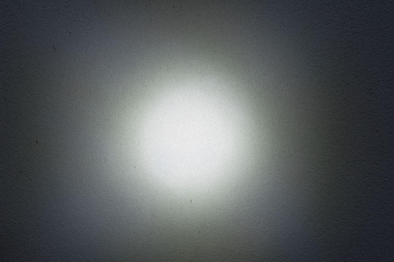 A light source shone at a black wall to show the beam shape