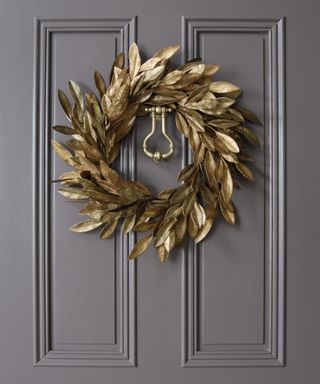 Thanksgiving wreath ideas with gold painted leaves on a grey door