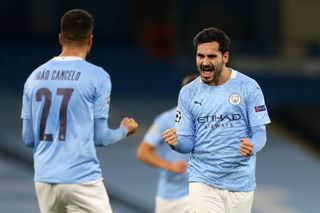 Ilkay Guendogan of Manchester City celebrates with teammate Joao Cancelo after scoring his team's second goal during the UEFA Champions League Group C stage match between Manchester City and FC Porto at Etihad Stadium on October 21, 2020 in Manchester, England. Sporting stadiums around the UK remain under strict restrictions due to the Coronavirus Pandemic as Government social distancing laws prohibit fans inside venues resulting in games being played behind closed doors.
