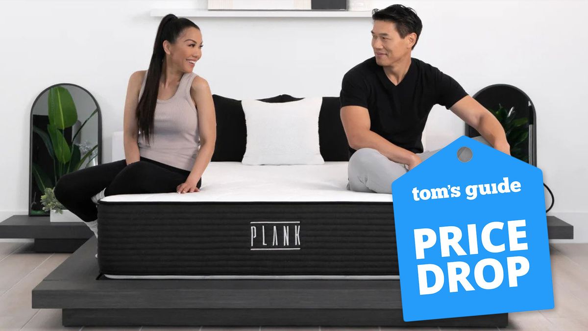 A man and woman sit either side of their new Plank Firm Mattress