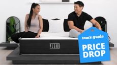 A couple sit and talk on a queen size Plank Firm mattress, which is on sale this weekend