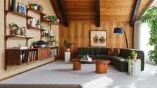 a mid century living room with paneled walls and a vintage shelving system