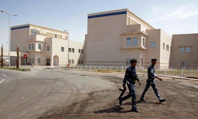 Iraqi police walk past the Basra Children’s Hospital, August 12, 2010.