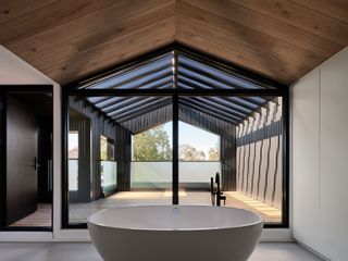 bathroom under pitched roof at Everden house by archollab