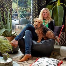 abigail ahern with her dog sitting on black armchair