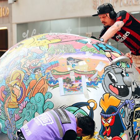 two men drawing on a giant ball