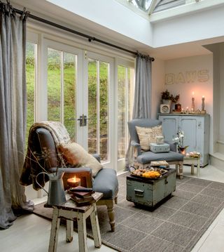 conservatory with white wall and glass door with curtains and armchair