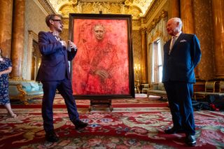 Artist Jonathan Yeo and King Charles III stand in front of the portrait of the King Charles III by artist Jonathan Yeo as it is unveiled in the blue drawing room at Buckingham Palace on May 14, 2024 in London, England.
