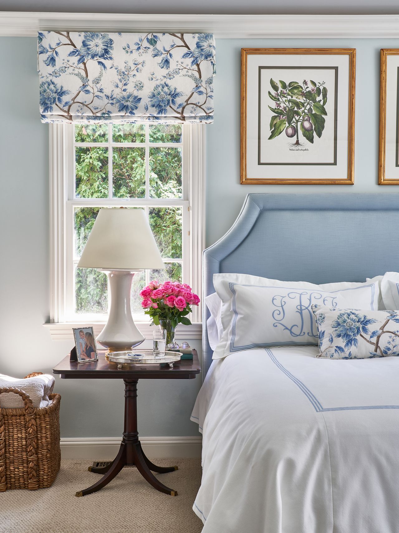 A bedroom with blue headboard and white patterned linen