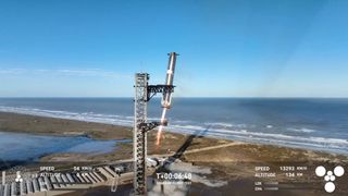 a large silver rocket is caught by its launch tower at a seaside pad