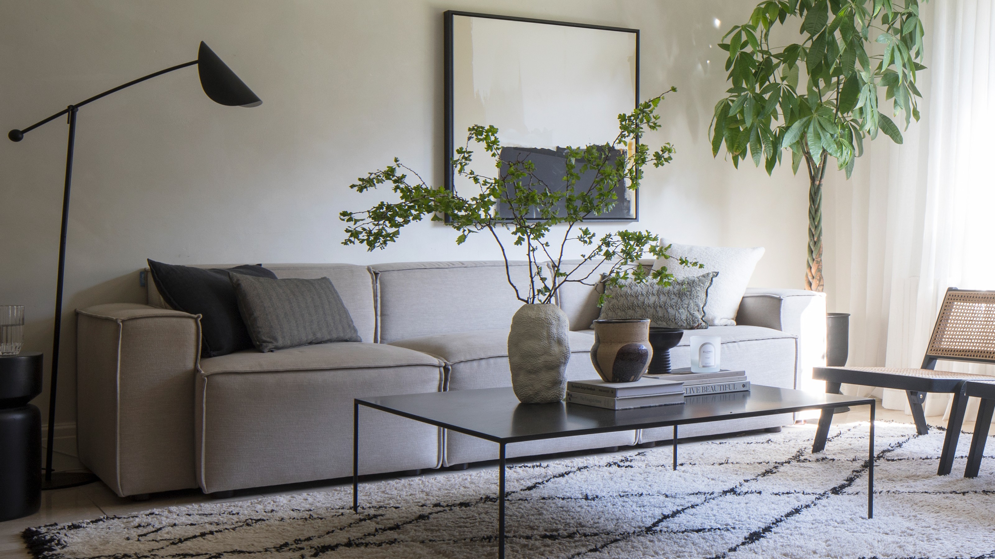 A living room with the Swyft Model 03 modular sofa in grey and a Berber-style rug