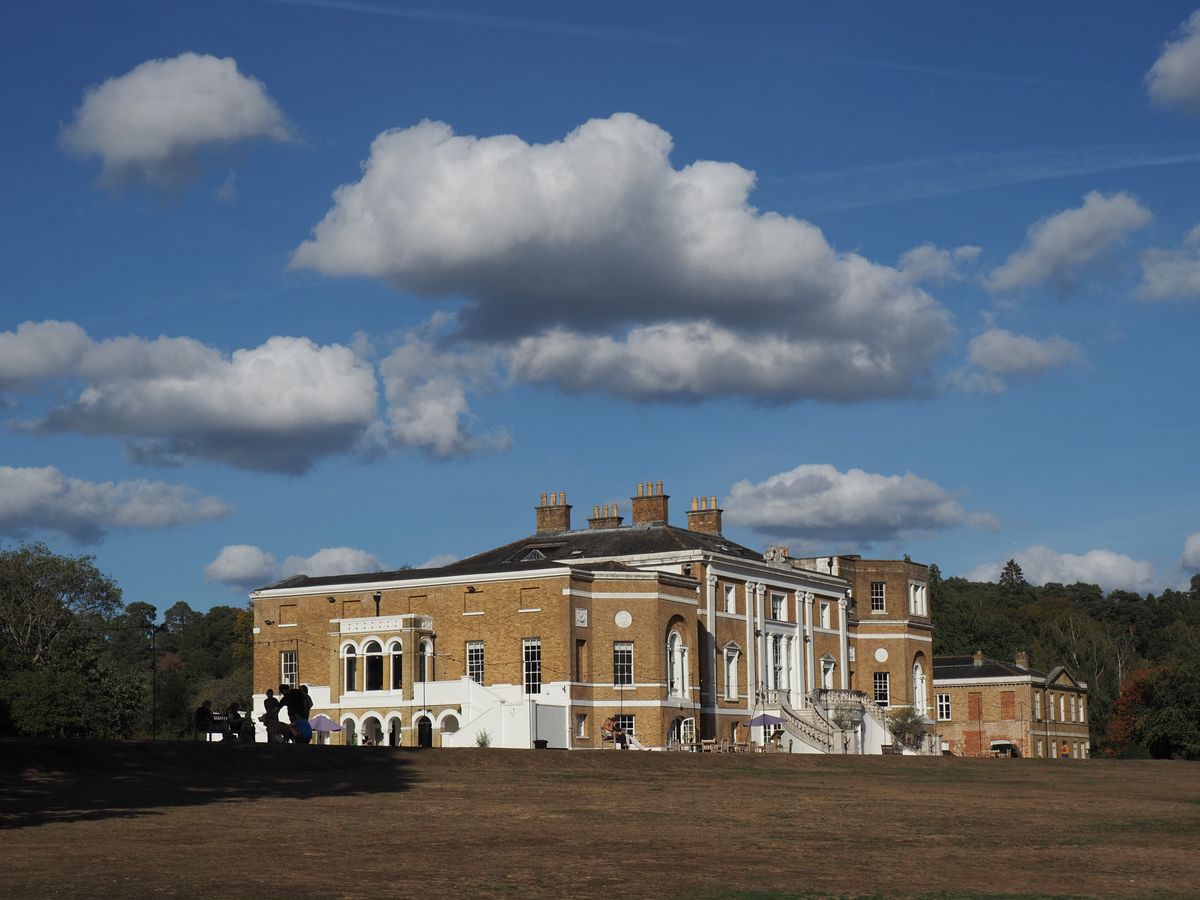 OM System PEN sample gallery: a grand house atop a field, there are dramatic clouds perfectly aligned above it