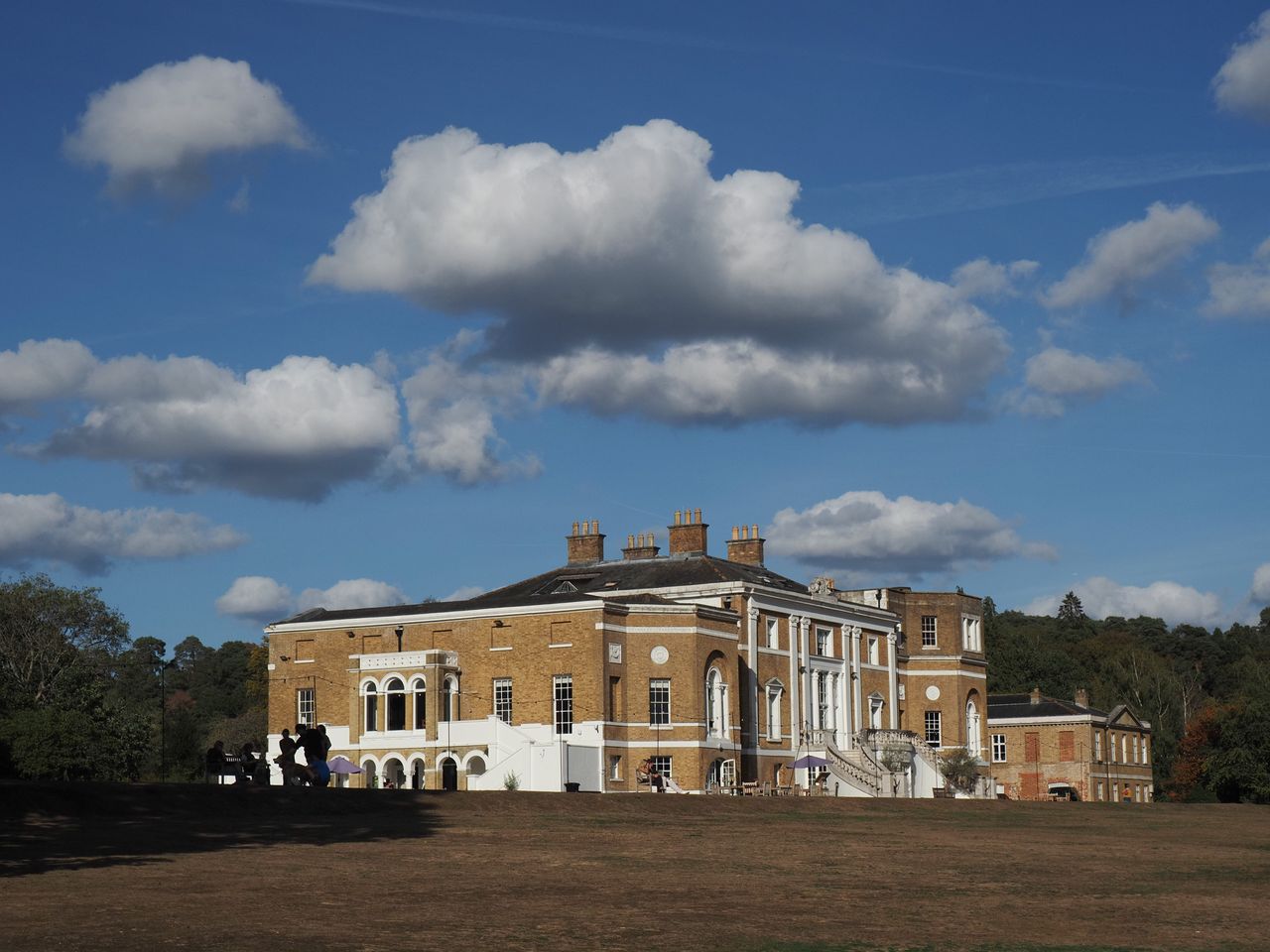 OM System PEN sample gallery: a grand house atop a field, there are dramatic clouds perfectly aligned above it