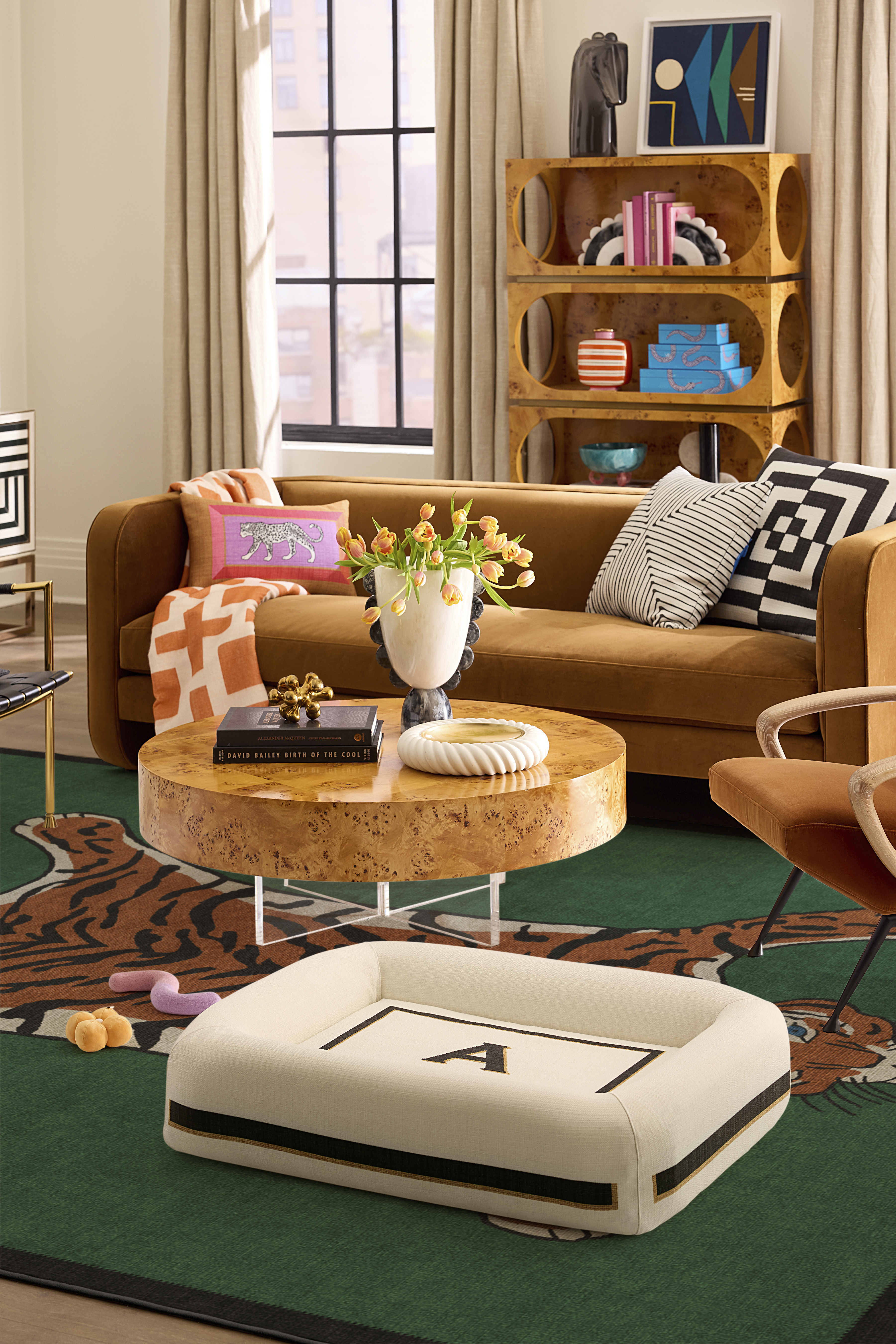 Jonathan Adler x Ruggable monogram pet bed pictured atop a tiger motif rug in a punchy mid-century-style living room