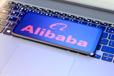 Alibaba logo on a smartphone that's placed on top of a laptop keyboard