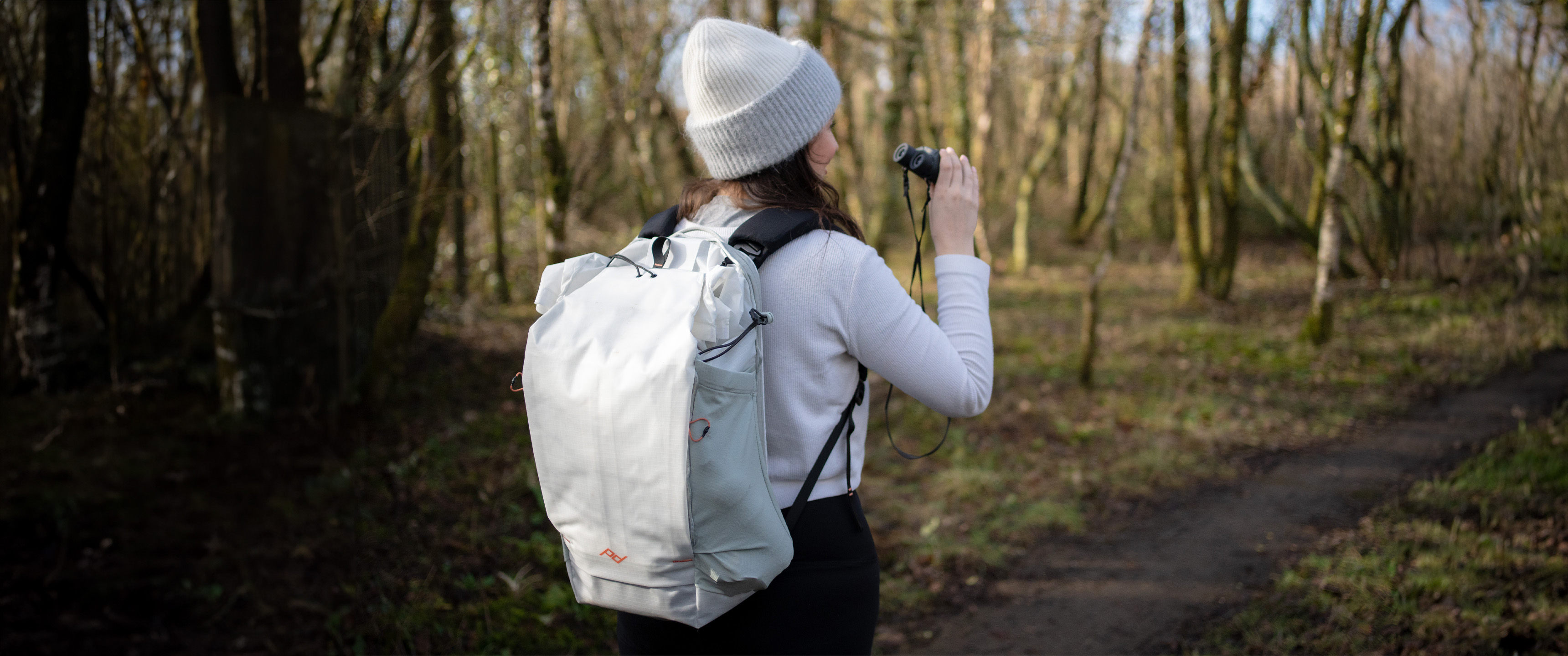woman wearing the peak design outdoor backpack in a nature reserve