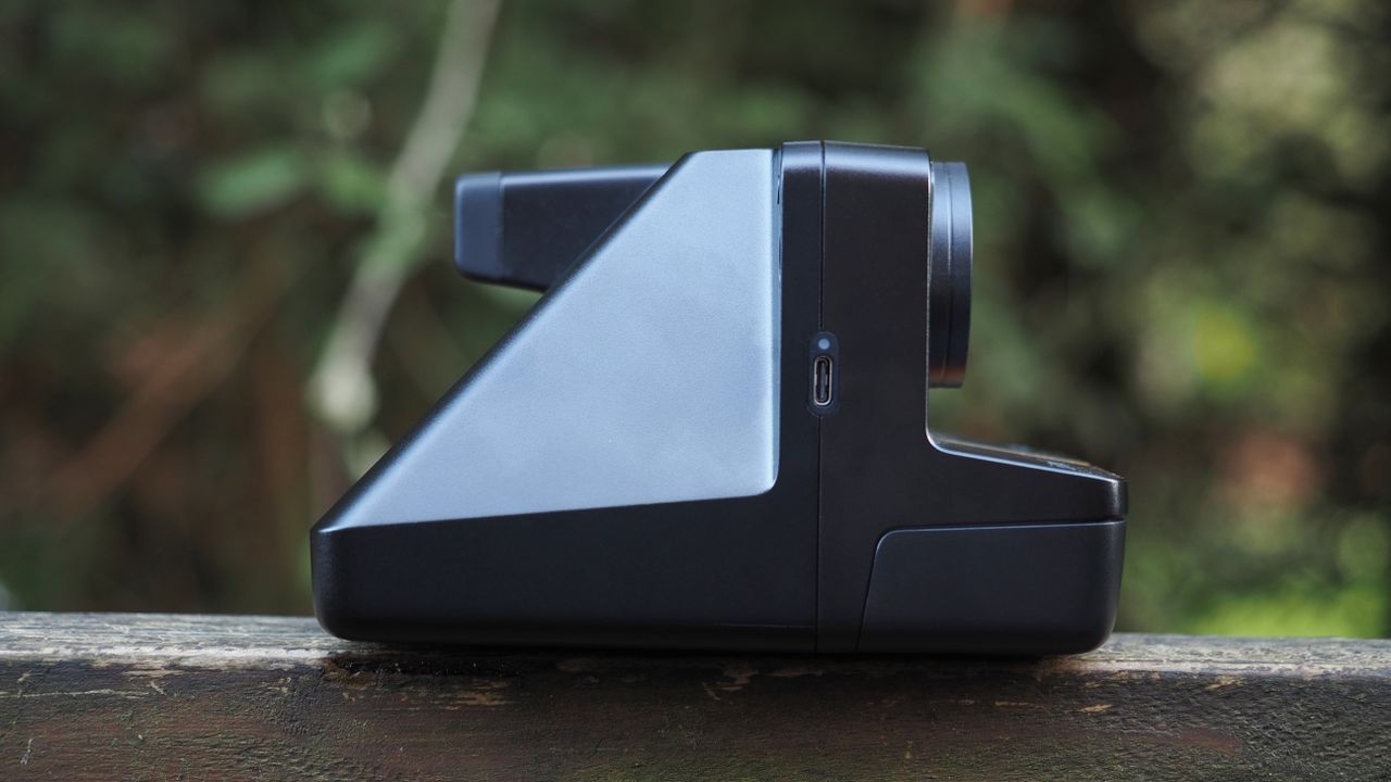 Polaroid Now+ Generation 2 on a wooden surface, in a woodland setting